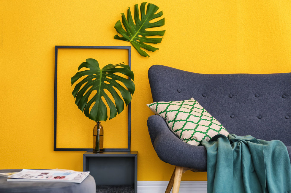A living room with yellow walls and plants.