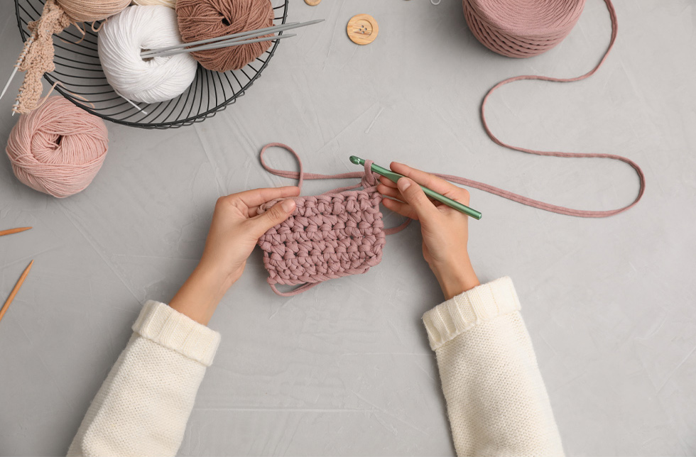 A person crocheting.